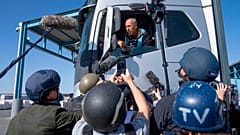 Un camionero recoge ayuda destinada a Gaza, mientras periodistas recorren el lado palestino del cruce de Kerem Shalom, el 19 de diciembre de 2024