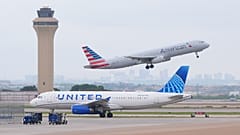 Bir American Airlines uçağı havalanırken bir United Airlines uçağı da 14 Nisan Salı günü Grapevine, Teksas'taki DFW Uluslararası Havalimanı pistinde taksi yapıyor.