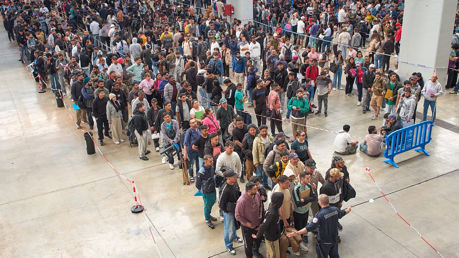 Los migrantes hacen cola en una oficina de servicios públicos para obtener la documentación necesaria para solicitar la amnistía migratoria española