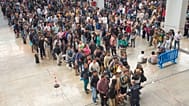 Los migrantes hacen cola en una oficina de servicios públicos para obtener la documentación necesaria para solicitar la amnistía migratoria española