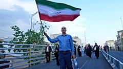 رجل يحمل العلم الإيراني في مسيرة نظمتها الدولة في طهران، إيران، الأربعاء 29 أبريل/نيسان 2026