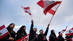 أشخاص يلوّحون بالأعلام اللبنانية خلال وقفة حداد على ضحايا قُتلوا في لبنان خلال الحرب مع إيران، في ديربورن بولاية ميشيغان الأميركية، الجمعة 10 أبريل/نيسان 2026