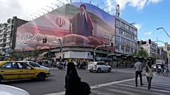  يمر الناس أمام لوحة إعلانية تعرض رسماً بيانياً يصور المرشد الأعلى الإيراني آية الله مجتبى خامنئي في وسط مدينة طهران، إيران، يوم الاثنين 6 أبريل 2026.