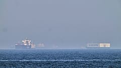 A tanker, left, and a car carrier are anchored at sea in the Gulf of Oman near the Strait of Hormuz, as seen from the coast near Khor Fakkan, United Arab Emirates, Friday, May