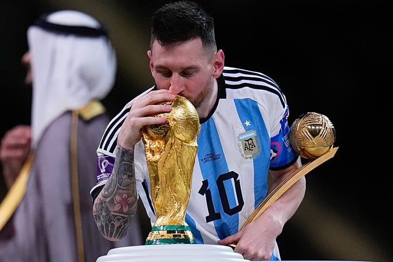 Lionel Messi bacia il trofeo mentre tiene in mano il Pallone d'Oro come miglior giocatore del torneo dopo aver vinto la finale della Coppa del Mondo di calcio al Lusail Stadium, a Lusail.