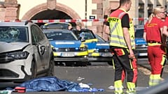 Rescue workers stand next to a damaged car that has crashed into several people in Leipzig, Germany, Monday, May 4, 2026.