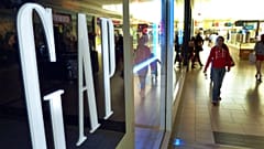 FILE - Shoppers walk by the GAP store at a shopping mall in Peabody, Mass, the company Doris Fisher and her late husband Donald founded in San Francisco, May 14, 2012