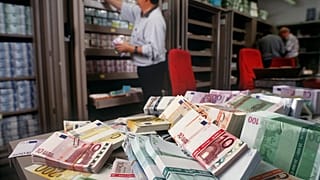 Euro banknotes are piled up on a table in the foreign exchange department of UBS bank in Zurich, Switzerland, in this Dec. 13, 2001 file photo.