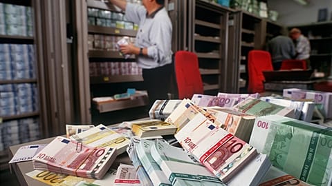 Euro banknotes are piled up on a table in the foreign exchange department of UBS bank in Zurich, Switzerland, in this Dec. 13, 2001 file photo.