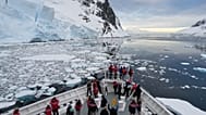 Passengers watch as a ship sails through the Lemaire Channel in Antarctica, Monday, Nov. 24, 2025.