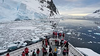 Passengers watch as a ship sails through the Lemaire Channel in Antarctica, Monday, Nov. 24, 2025.