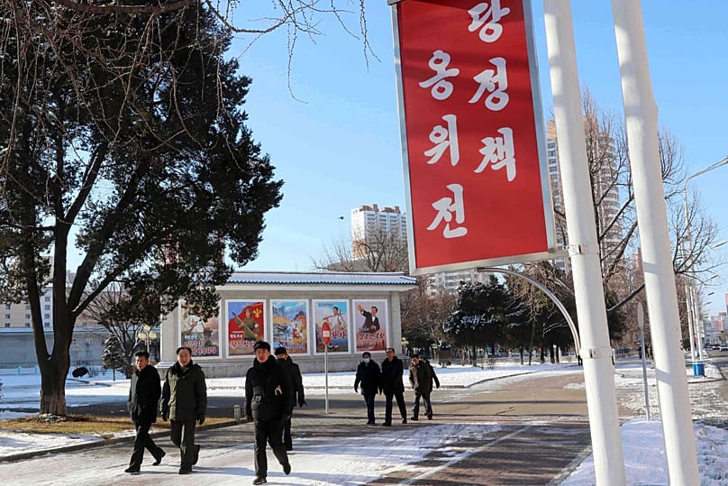 People walk in the street of the Central District of Pyongyang, 25 December, 2025