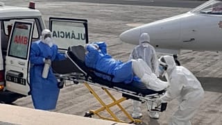 Uno de los evacuados, sale del vehículo para ser trasladado al aviónmedicalizado