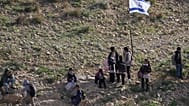 طلاب فلسطينيون يسيرون إلى المدرسة على طول سياج يفصل قريتهم عن مستوطنة الكرمل الإسرائيلية القريبة