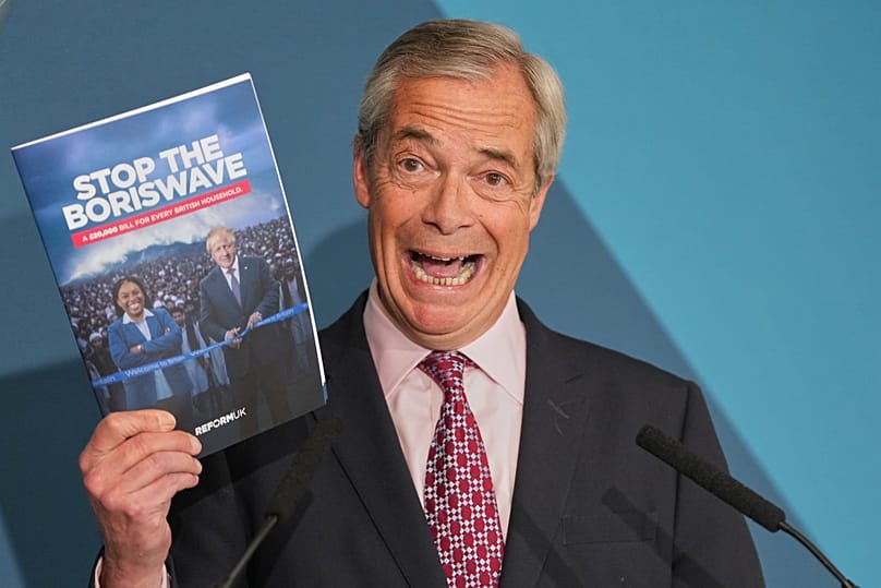 Nigel Farage leader of the Reform UK party holds up a booklet during a press conference in London, 13 April, 2026