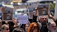 صحافيون يرفعون صحفاً تظهر صور الصحافية اللبنانية أمل خليل التي قُتلت الأربعاء في غارة جوية إسرائيلية.