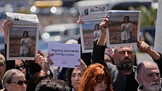 صحافيون يرفعون صحفاً تظهر صور الصحافية اللبنانية أمل خليل التي قُتلت الأربعاء في غارة جوية إسرائيلية.