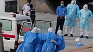Medizinisches Personal in Schutzkleidung bringt Passagiere vom Kreuzfahrtschiff MV Hondius in Krankenwagen.