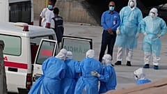 Health workers in protective gear evacuate patients from the MV Hondius cruise ship into an ambulance