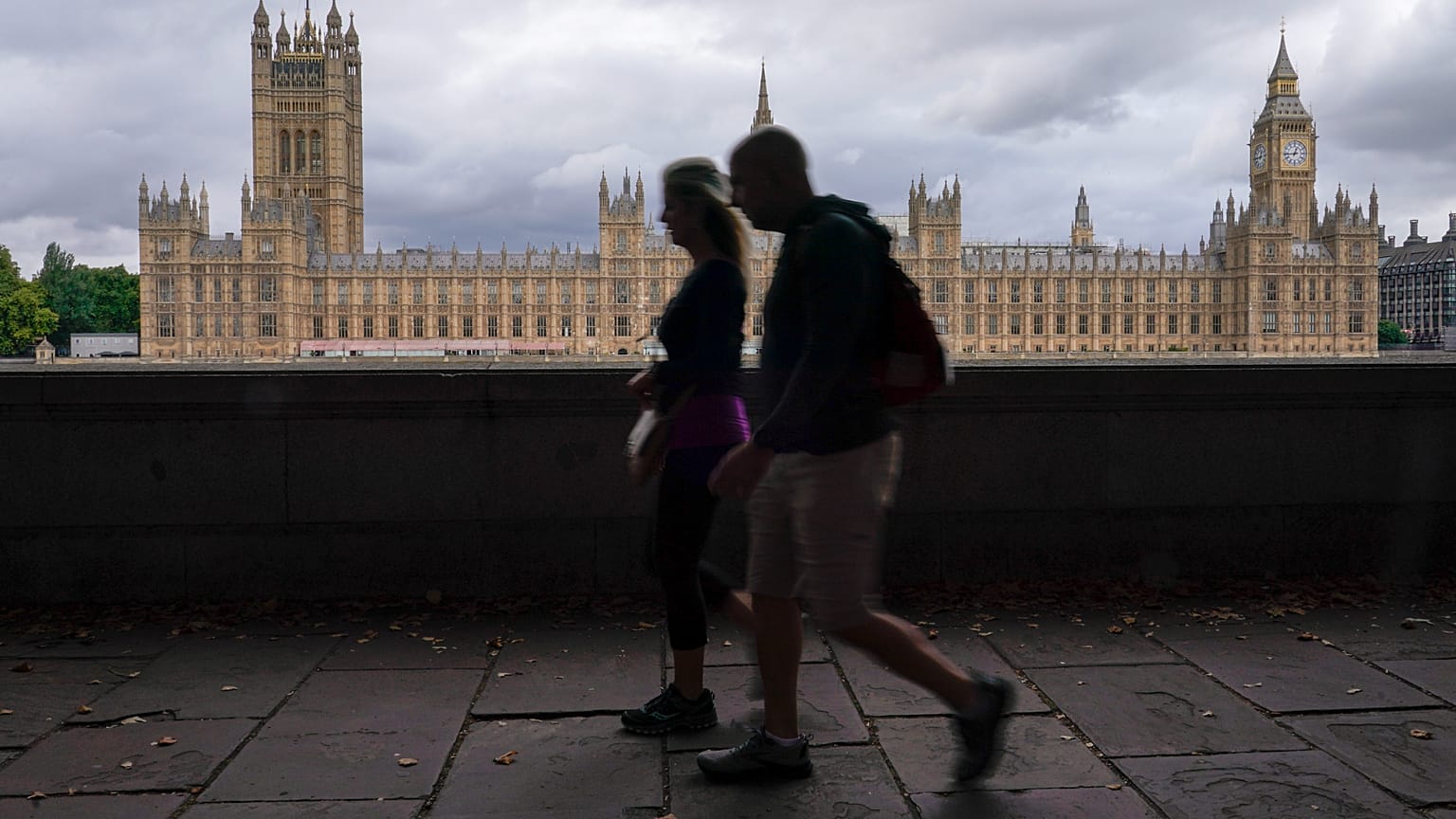 ARCHIVIO. Persone camminano sulla riva sud del Tamigi, con il Palazzo di Westminster sullo sfondo, a Londra, 22 ago 2022
