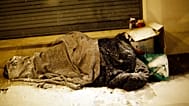 A homeless man sleeps during a snowfall in Issy les Moulineaux, west of Paris