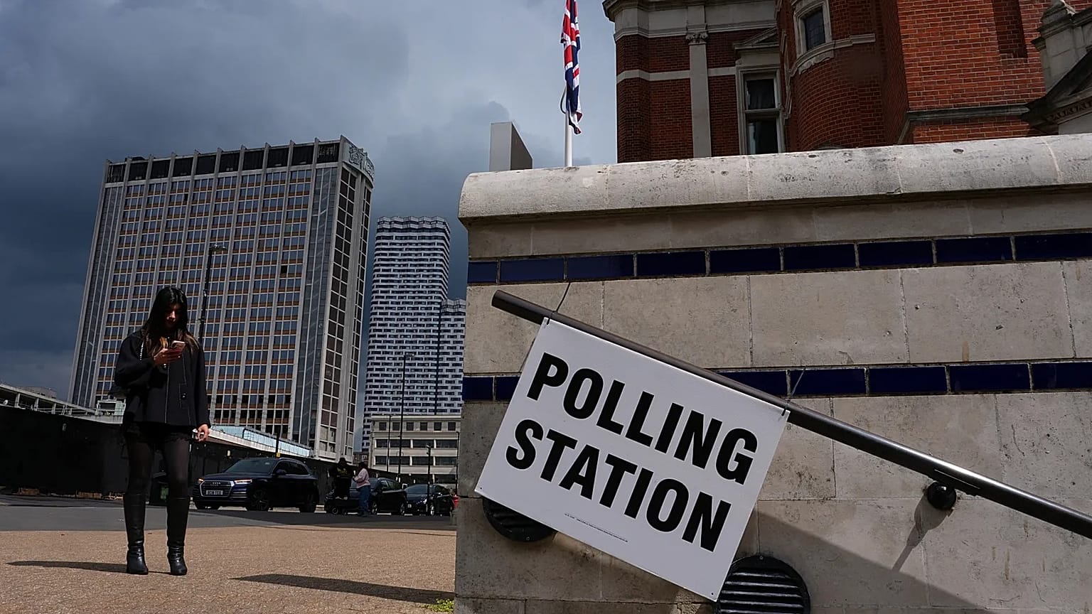 A pedestrian walks past a polling station sign during the UK local elections in London, 7 May, 2026