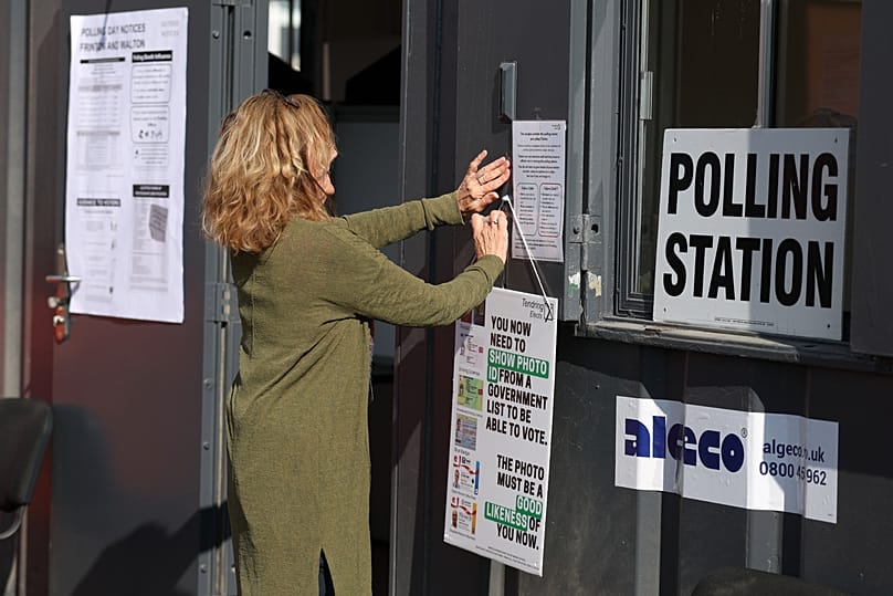 A worker prepares signs at a polling station for local elections in Walton on the Naze, 7 May, 2026 