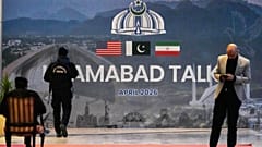 يمر حارس أمن بجوار لوحة إعلانية تتعلق بالمحادثات الأمريكية الإيرانية، خارج مركز إعلامي أُقيم لتغطية الاجتماع الرسمي بين الولايات المتحدة وإيران، في إسلام أباد بباكستان