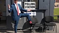 Nigel Farage, leader of the British populist party Reform UK, shows off his socks as he arrives at a polling station in Walton-on-the-Naze,