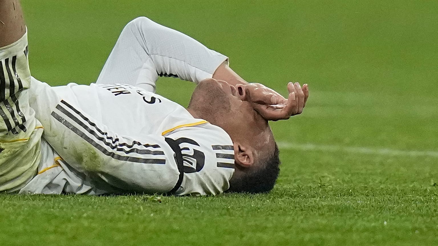 Real Madrid's Kylian Mbappe lies on the pitch after injuring during the Champions League quarterfinal second leg soccer match between Bayern Munich and Real Madrid in Munich