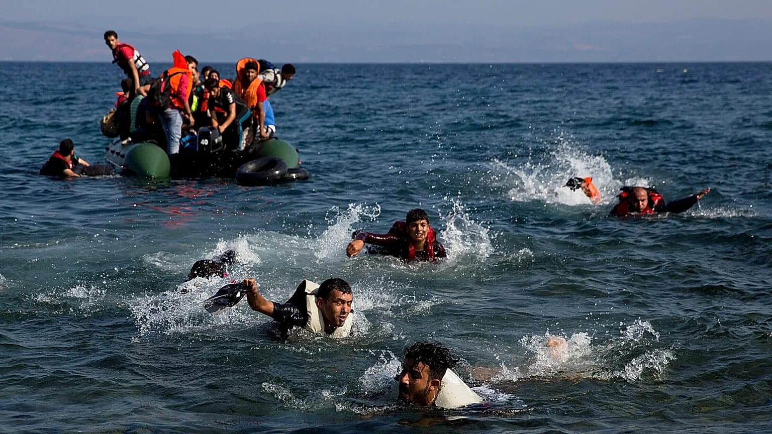 Migranten, deren Boot bei der Überfahrt von der Türkei nach Griechenland stecken geblieben ist, schwimmen zur Insel Lesbos, 20. September 2015