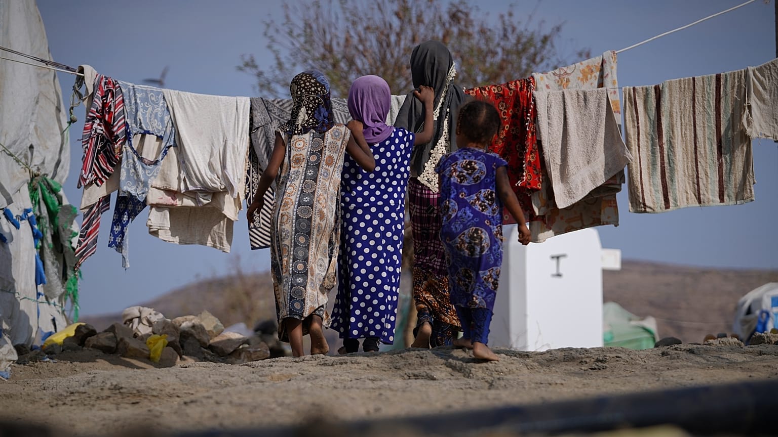 أطفال نازحون يقفون أمام خيامهم في مخيم مؤقت للعائلات في منطقة البركان بريف تعز باليمن، الجمعة 13 مارس 2026. (صورة AP/عبد الناصر الصديق)