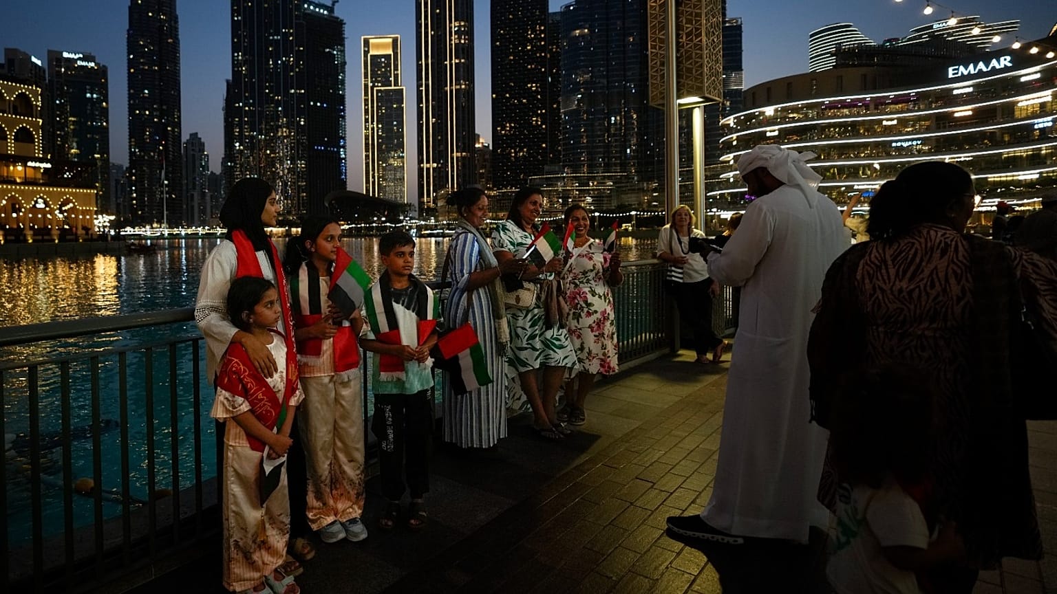 الزوار يحملون الأعلام أثناء التقاط الصور في وسط مدينة دبي، الإمارات العربية المتحدة، الأربعاء 6 مايو 2026. 