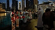الزوار يحملون الأعلام أثناء التقاط الصور في وسط مدينة دبي، الإمارات العربية المتحدة، الأربعاء 6 مايو 2026. 