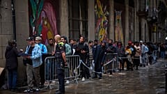 Una cola de inmigrantes espera fuera para regularizar su situación.