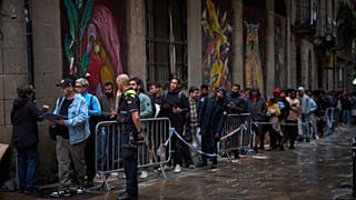 Una cola de inmigrantes espera fuera para regularizar su situación.