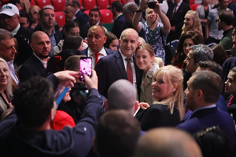Former Bulgarian President Rumen Radev poses with a supporter at the closing rally of his campaign, in Sofia, Thursday, April 16, 2026
