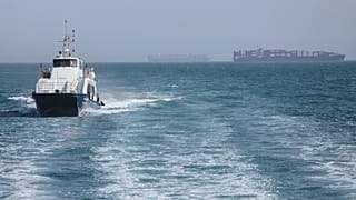 يتحرك زورق دورية عبر المياه بينما ترسو سفن الشحن في مضيق هرمز قبالة بندر عباس، إيران، السبت 2 مايو 2026.(أمير حسين خورجوي/ISNA عبر AP)