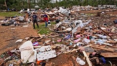 People walk among debris at Gene's Mobile Home Supply, a trailer park in Bogue Chitto, Miss., Thursday, May, 7, 2026,
