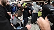 A group of supporters surround a woman with alleged ties to the Islamic State as she arrives with a child at Melbourne Airport, in Melbourne, Australia, Thursday, May 7, 2026