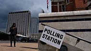 A pedestrian walks past a polling station sign in London, 7 May, 2026