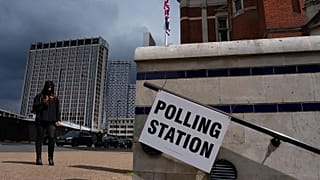 A pedestrian walks past a polling station sign in London, 7 May, 2026