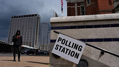 A pedestrian walks past a polling station sign in London, 7 May, 2026