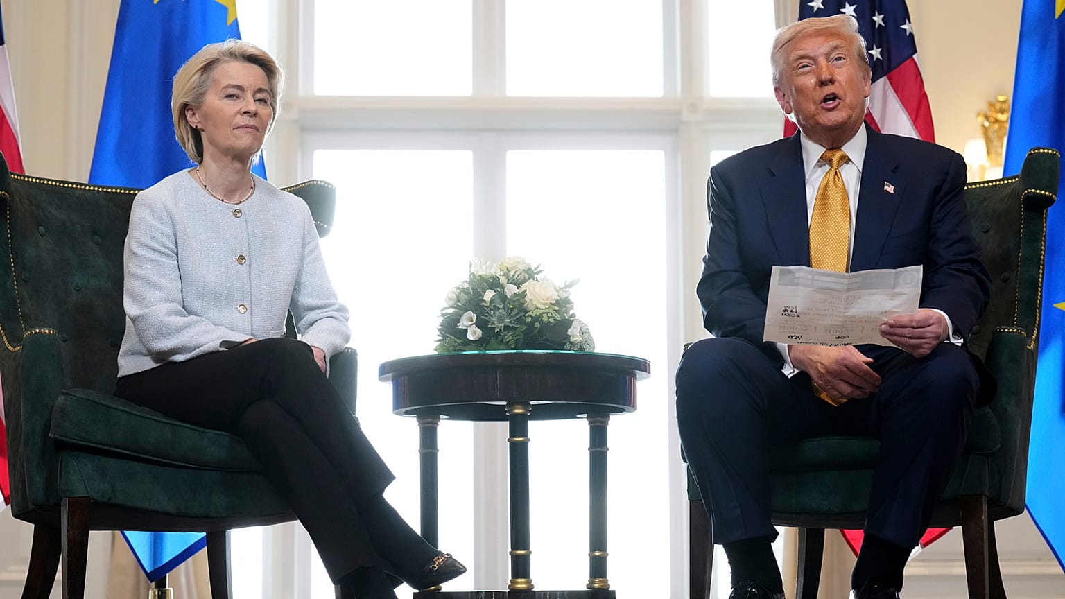 President Donald Trump reads from a paper and European Commission President Ursula von der Leyen listens after reaching a trade deal between the U.S. and the EU 