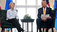 President Donald Trump reads from a paper and European Commission President Ursula von der Leyen listens after reaching a trade deal between the U.S. and the EU 