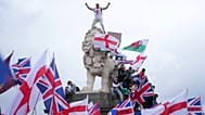Demonstrator stands on head of lion on the side of the Westminster Bridge, during a Tommy Robinson-led Unite the Kingdom march and rally in London, 13 September 2025.