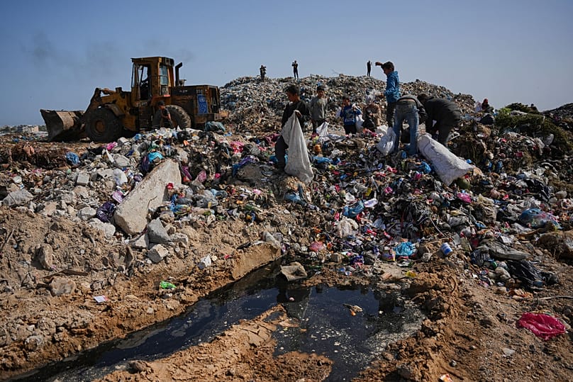 أطفال يبحثون عن مواد قابلة لإعادة الاستخدام في مكب نفايات بجوار مخيم يضم فلسطينيين نازحين في دير البلح وسط قطاع غزة، الخميس 16 أبريل 2026.