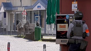 Αστυνομικός στέκεται στον τόπο του συμβάντος όπου σημειώθηκε ομηρία σε υποκατάστημα τράπεζας στο Σίνζιγκ, 8 Μαΐου 2026.