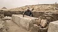 عامل آثار مصري ينظف سرير تحنيط تم اكتشافه حديثاً في موقع هرم زوسر المدرج في سقارة، على بعد 24 كيلومتراً (15 ميلاً) جنوب غرب القاهرة، مصر، السبت 27 مايو 2023. (صورة من وكالة أس