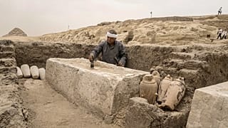عامل آثار مصري ينظف سرير تحنيط تم اكتشافه حديثاً في موقع هرم زوسر المدرج في سقارة، على بعد 24 كيلومتراً (15 ميلاً) جنوب غرب القاهرة، مصر، السبت 27 مايو 2023. (صورة من وكالة أس